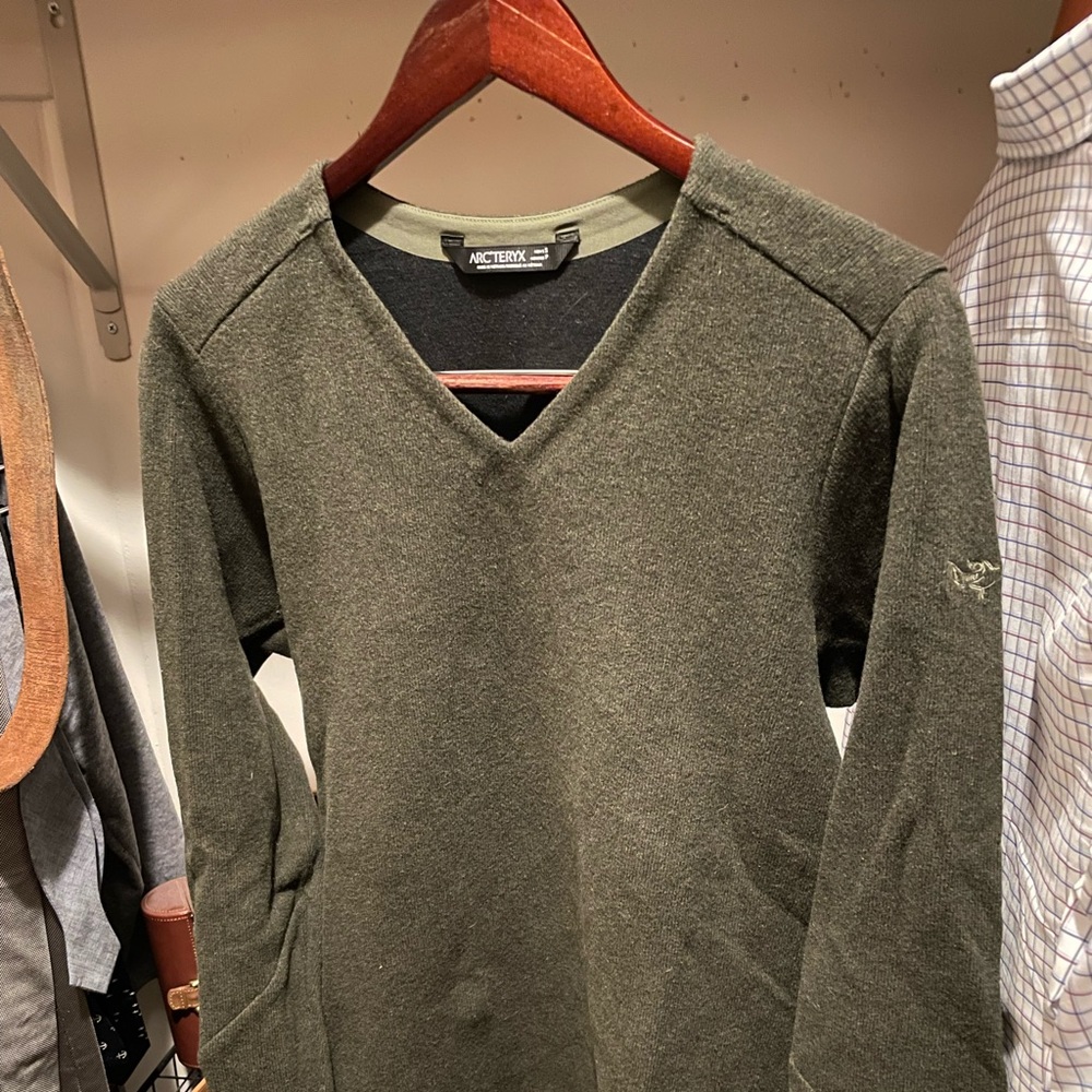 This is an olive green, V-neck sweater, size small.